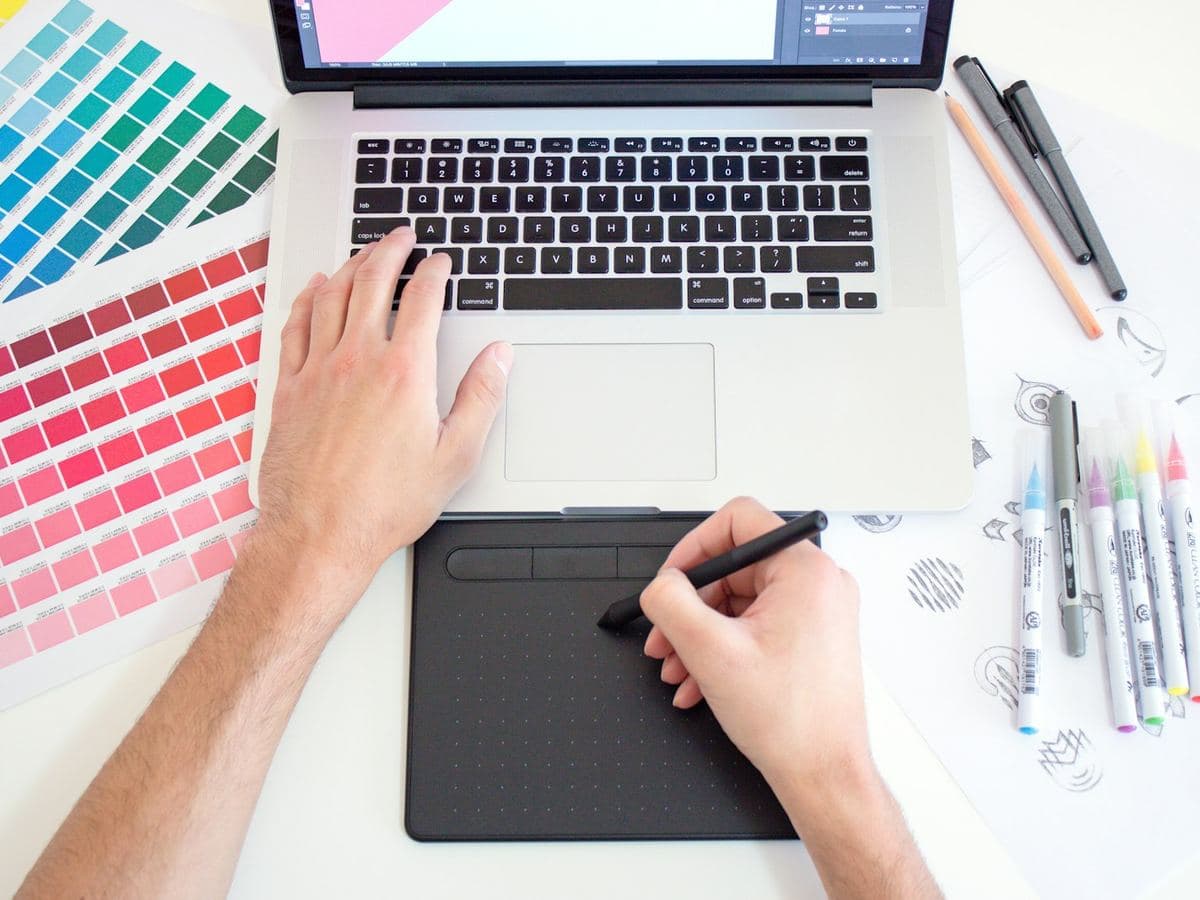 Designer working on a drawing tablet with color swatches