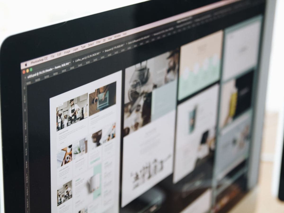 Website design layouts displayed on a desktop monitor