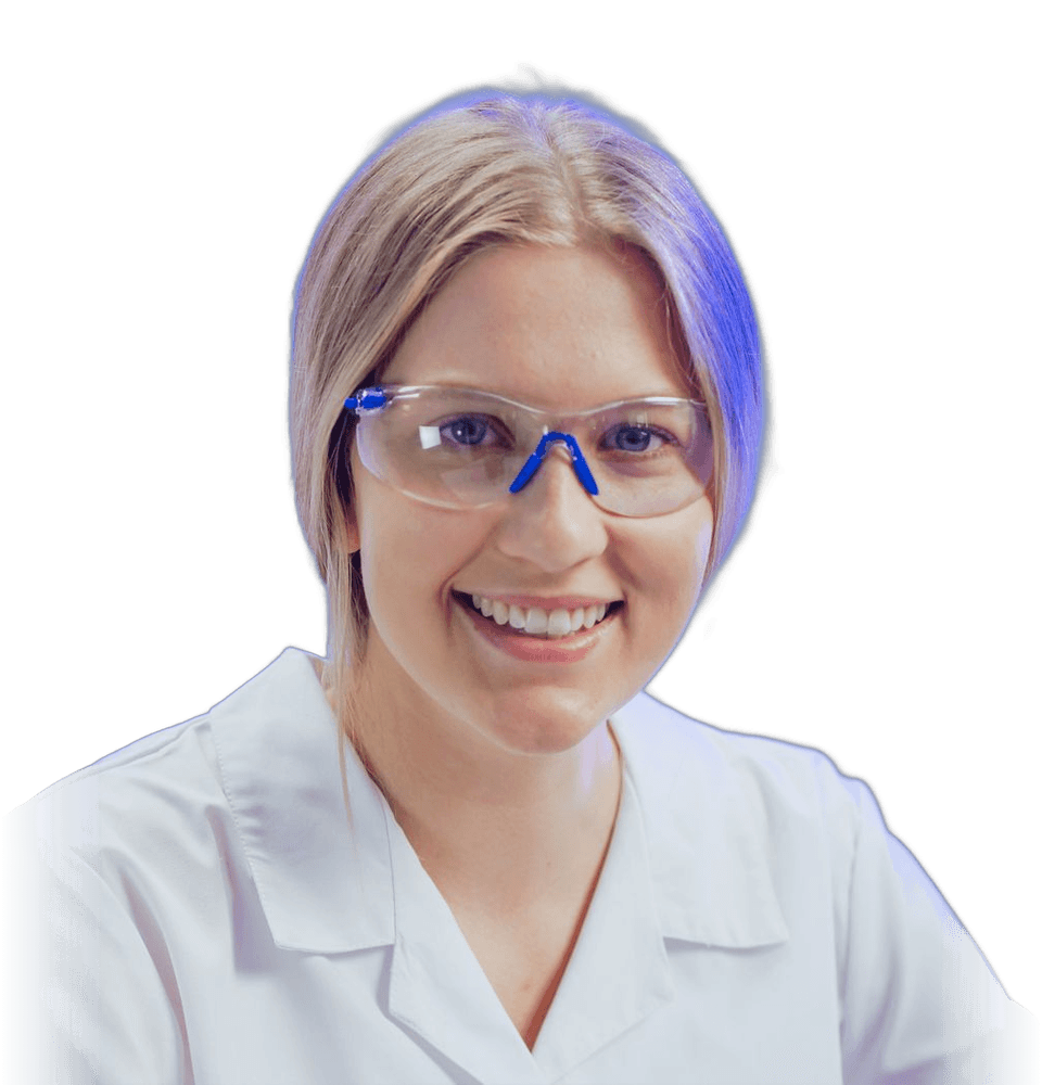 Smiling scientist in a lab coat and safety glasses
